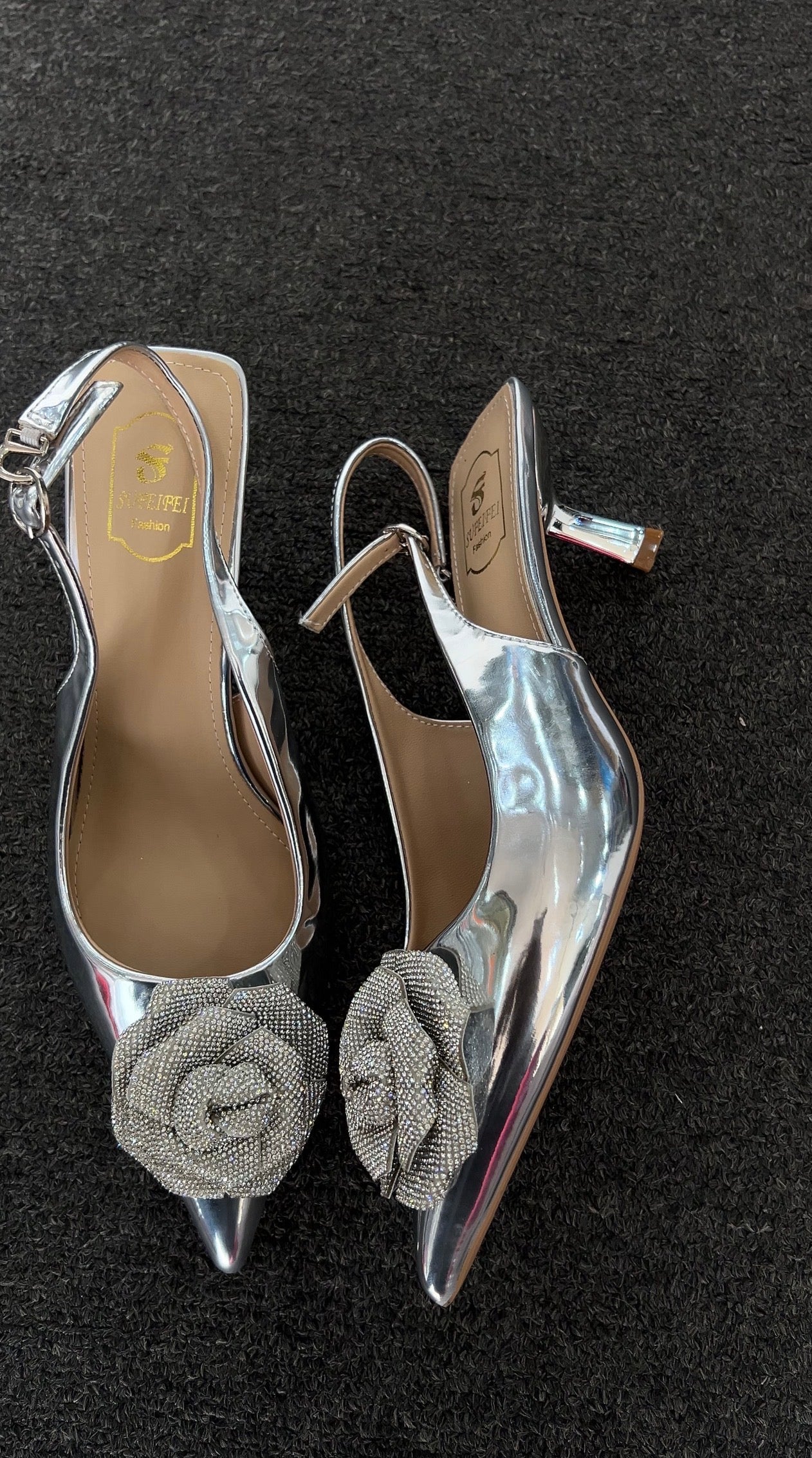 Pair of silver high-heeled shoes with floral embellishments