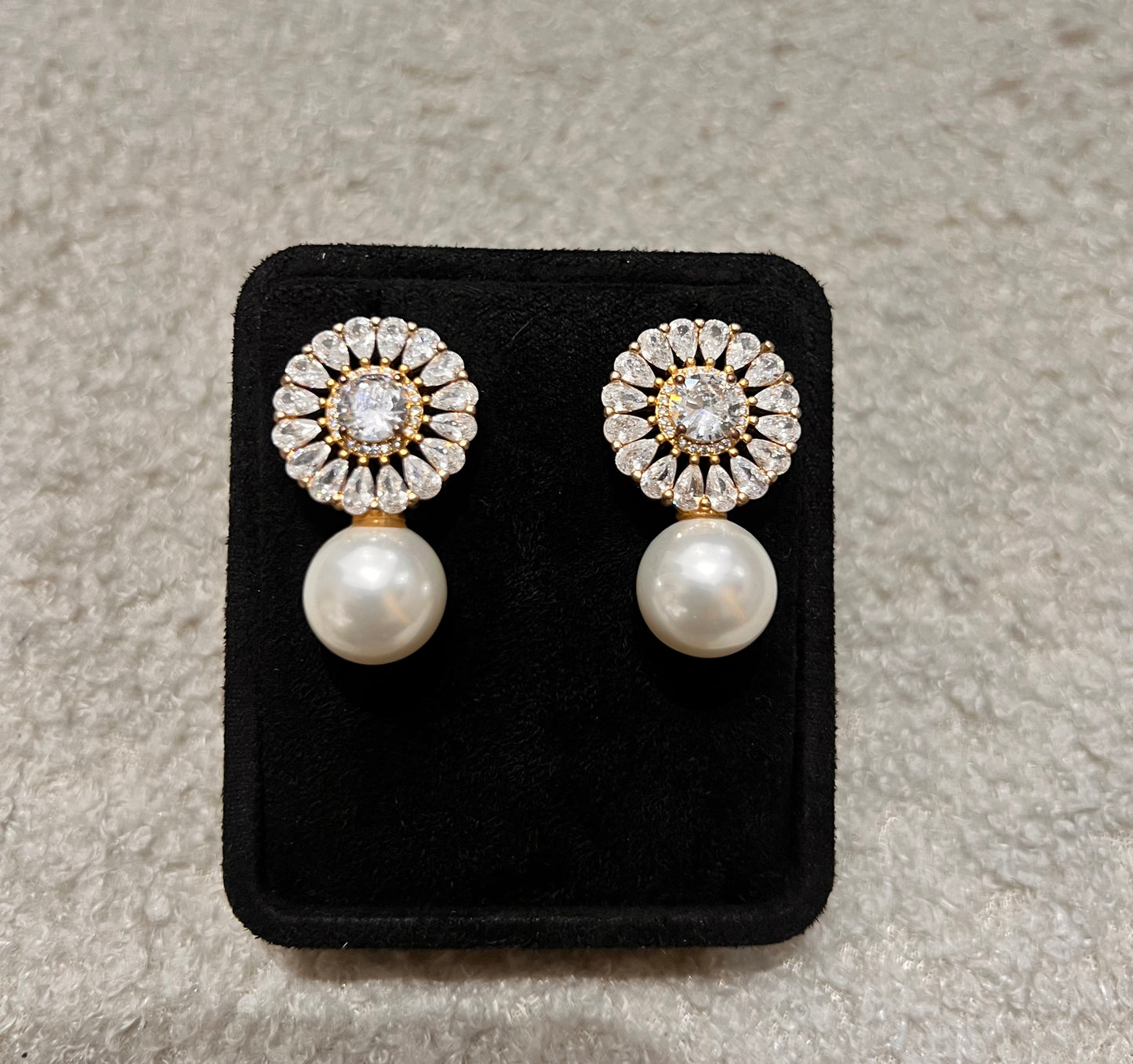Pair of earrings with pearl and diamond-like stones. A perfect blend of classic romance and modern glamour.