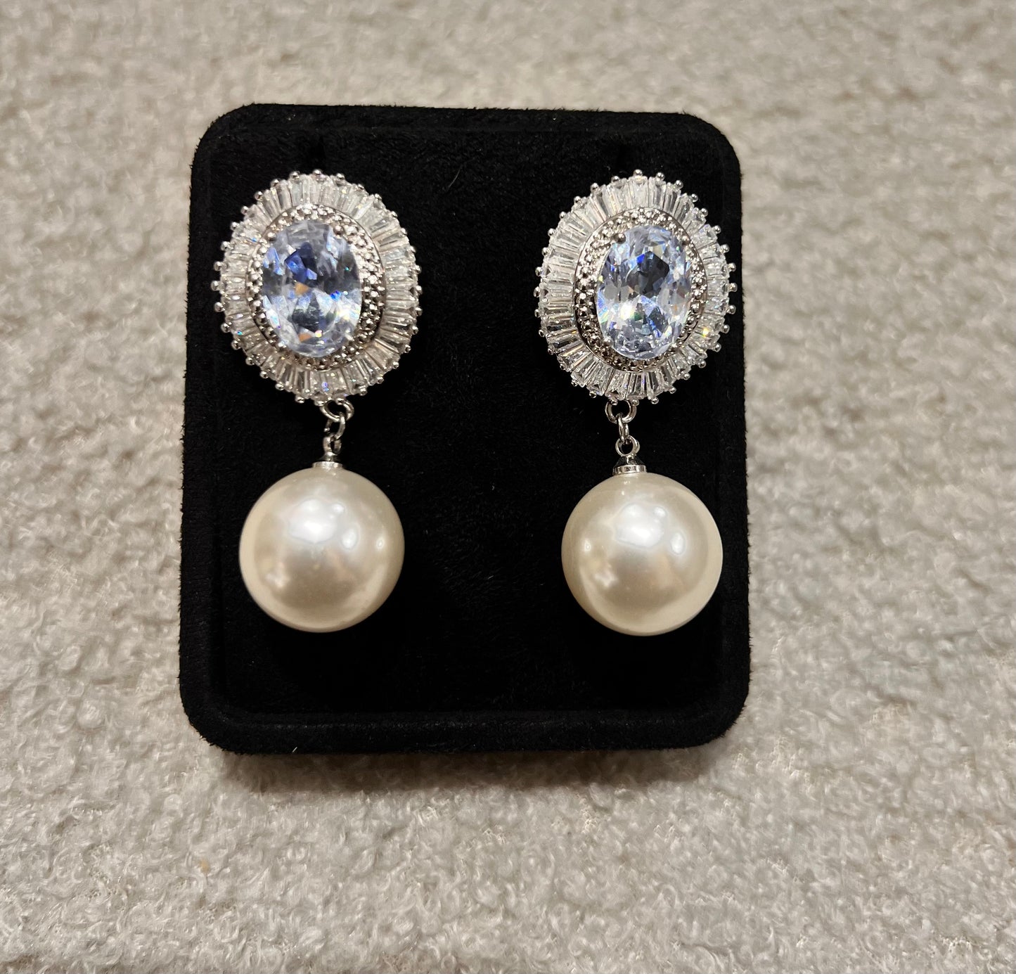 Pair of earrings with pearl drops and crystal-like tops.
