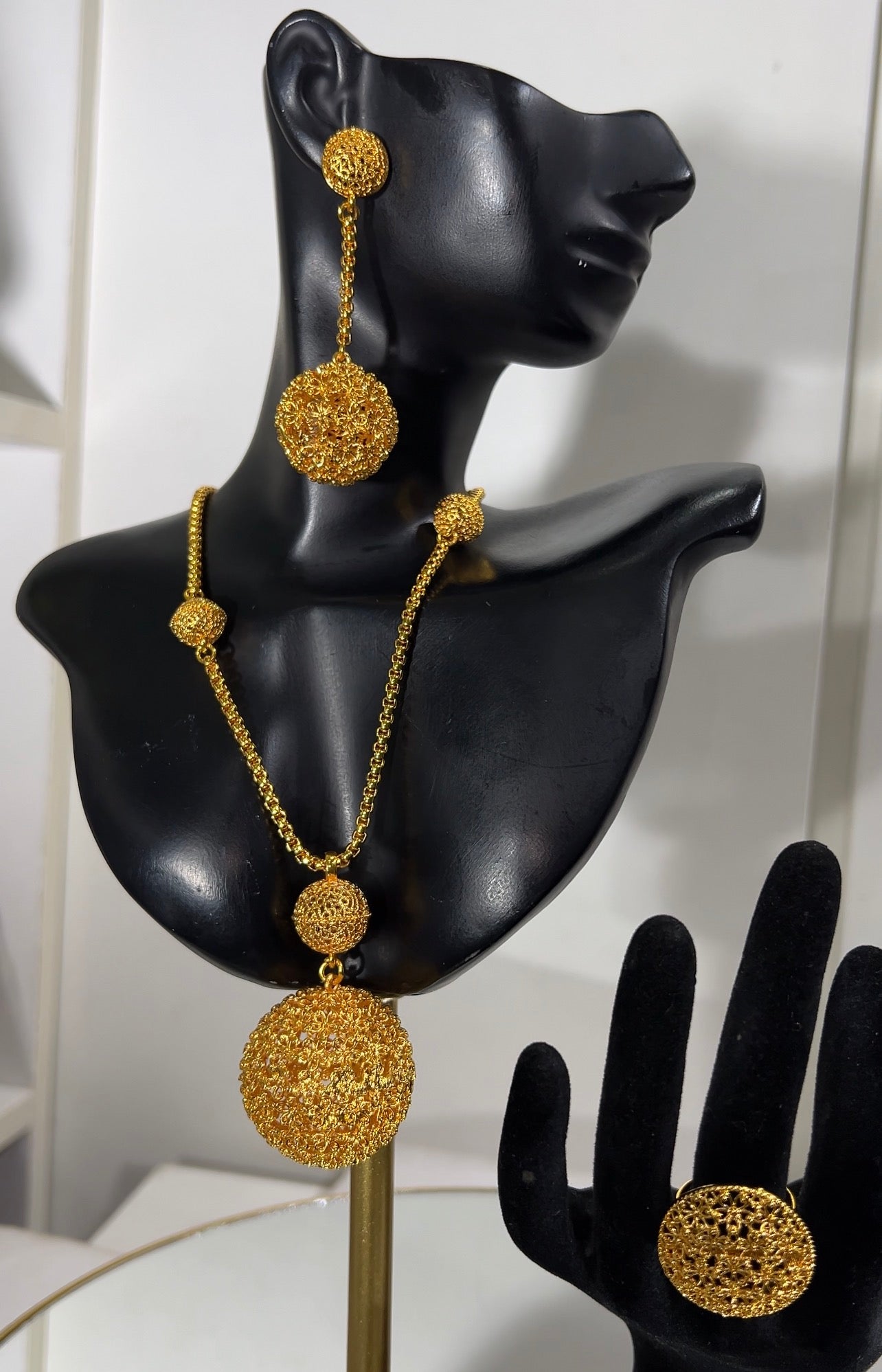 The accompanying long drop earrings replicate the exquisite spherical openwork, dangling elegantly from textured coin studs, paired seamlessly with a matching oversized filigree dome ring.