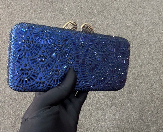 A royal blue beaded clutch purse with intricate circular patterns of rhinestones and beads