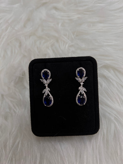 A pair of silver drop earrings with deep blue teardrop-shaped stones and small clear crystal accents, these drops dance beautifully with every turn of the head, offering a classic "something blue" for the traditional bride or a striking pop of color for an evening gown.