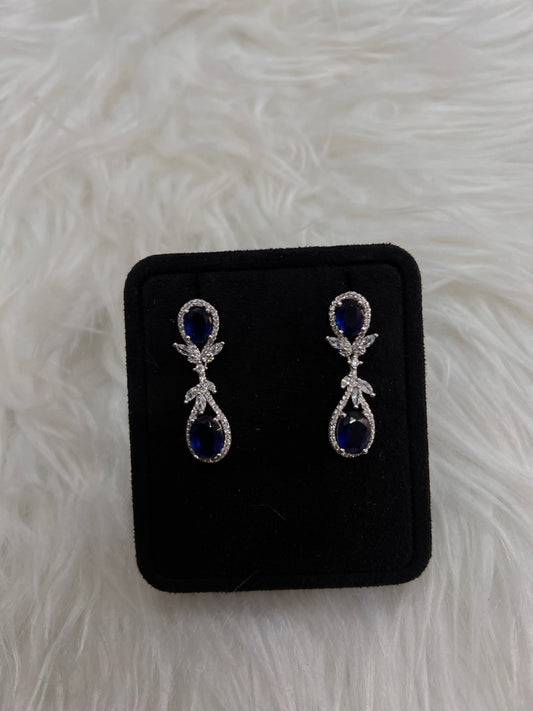 A pair of silver drop earrings with deep blue teardrop-shaped stones and small clear crystal accents, these drops dance beautifully with every turn of the head, offering a classic "something blue" for the traditional bride or a striking pop of color for an evening gown.