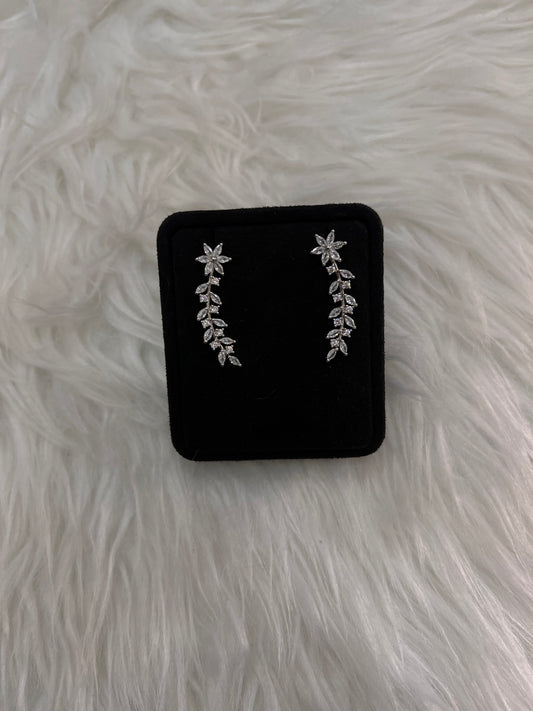 A pair of silver floral and leaf stud earrings.  they offer a high-impact sparkle that beautifully frames the face with effortless grace.