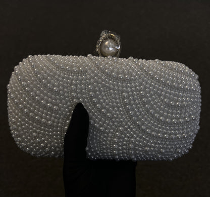  Its sleek shape is elevated by a prominent pearl top clasp, providing a refined, classic look for brides and formal guests.