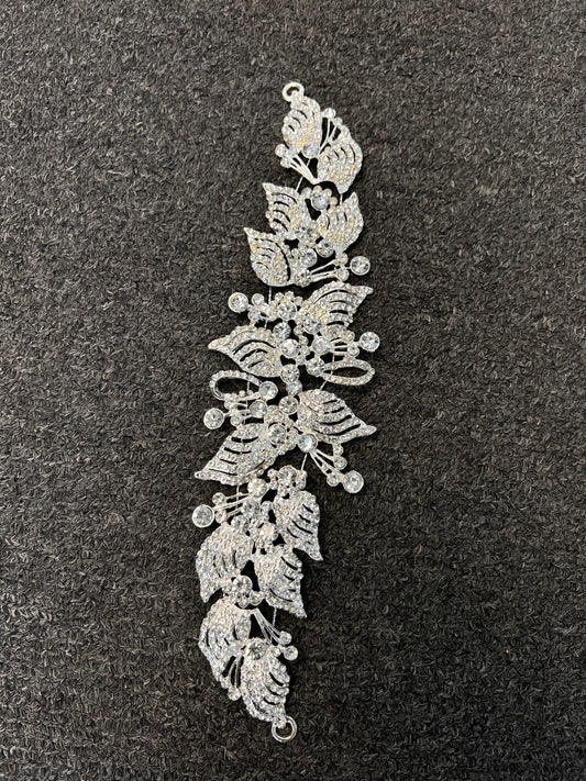 A silver-toned floral lace applique or hair embellishment with intricate leaf and flower cutouts Ideal for bridal hair, wedding parties, proms, and formal galas