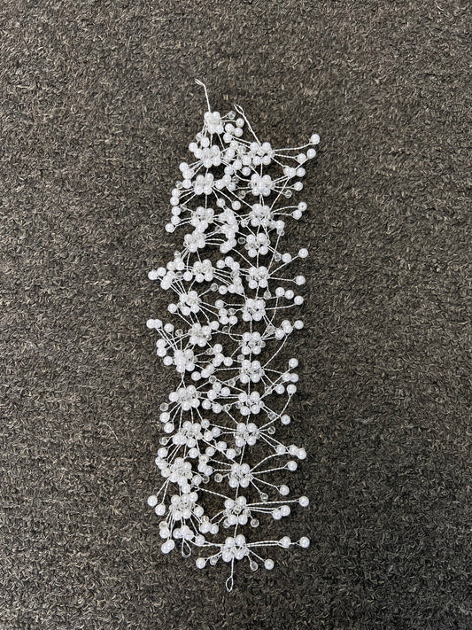 A white beaded floral hair accessory with small flower clusters and pearl-like beads. Perfect for brides, bridesmaids, galas, proms, and formal celebrations.