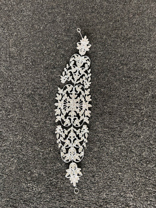 A silver-toned filigree dangle earring with intricate floral and scrollwork patterns. Designed with delicate end loops that easily fasten with bobby pins or ribbons for a comfortable, stay-put fit all day.