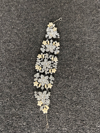 Detailed layered flower clusters and leaf sprigs designed to catch the light beautifully in wedding photos and under venue lighting.
