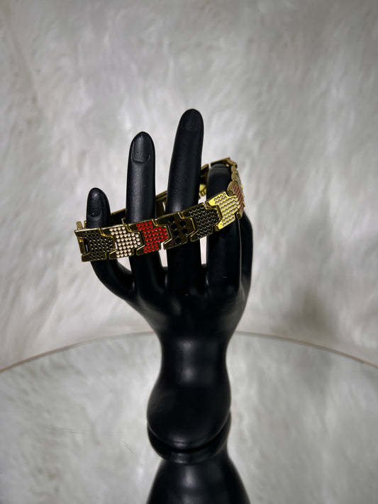 A gold-tone mesh bracelet with red and gold geometric inlay details, Combining high-polish metallic shine with colorful enamel accents, this eye-catching piece brings a luxurious, playful twist to statement wristwear.