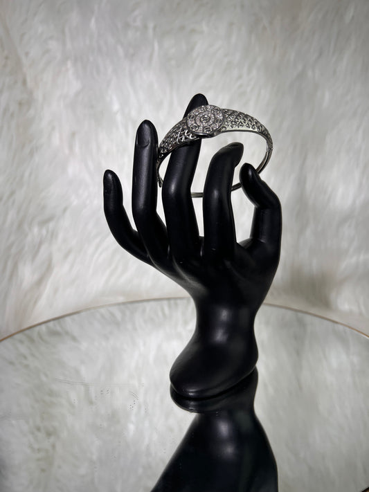 A silver-toned filigree ring with a central cluster of clear stones.
