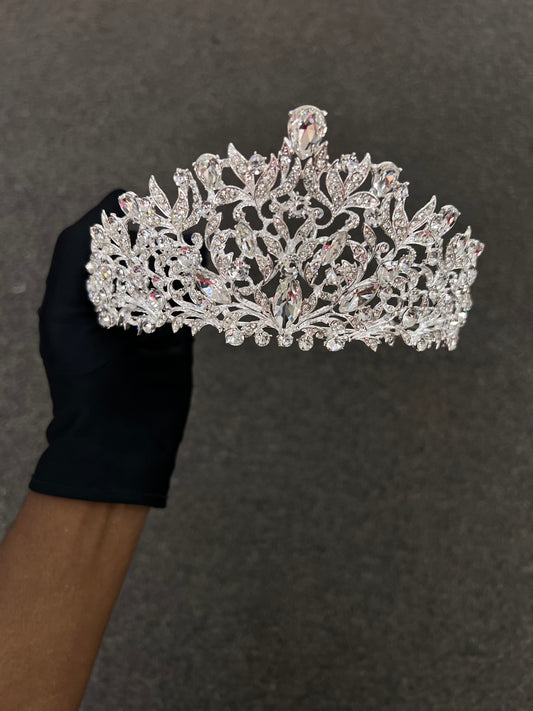 An ornate silver tiara adorned with clear rhinestones, Perfect for Classic ballgown wedding dresses, traditional cathedral veil pairings, and royal-themed bridal aesthetics.