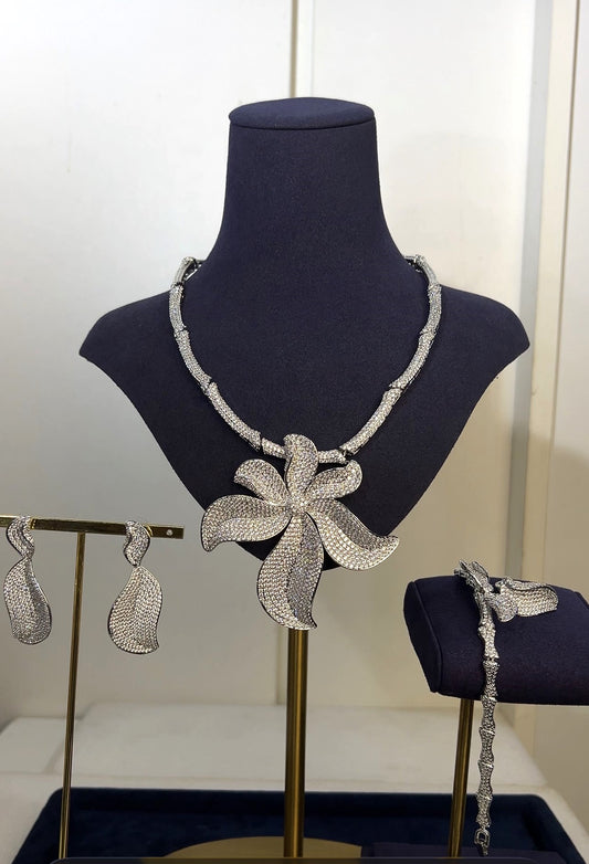 Silver jewelry set including necklace, earrings, and bracelet on a mannequin bust.