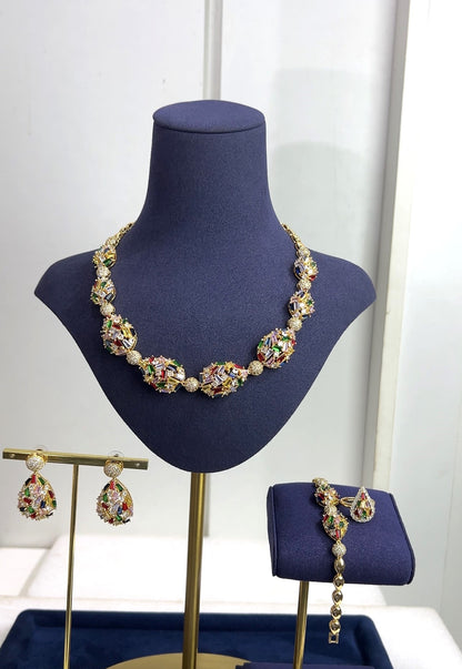 Jewelry set including necklace, earrings, and bracelet on a blue mannequin bust.