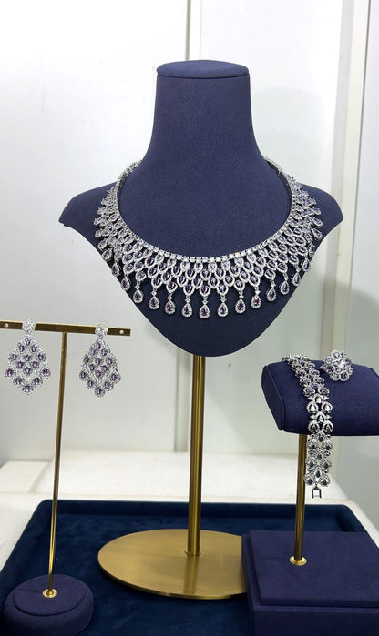 Jewelry set including necklace, earrings, and bracelet on a mannequin bust and stands.