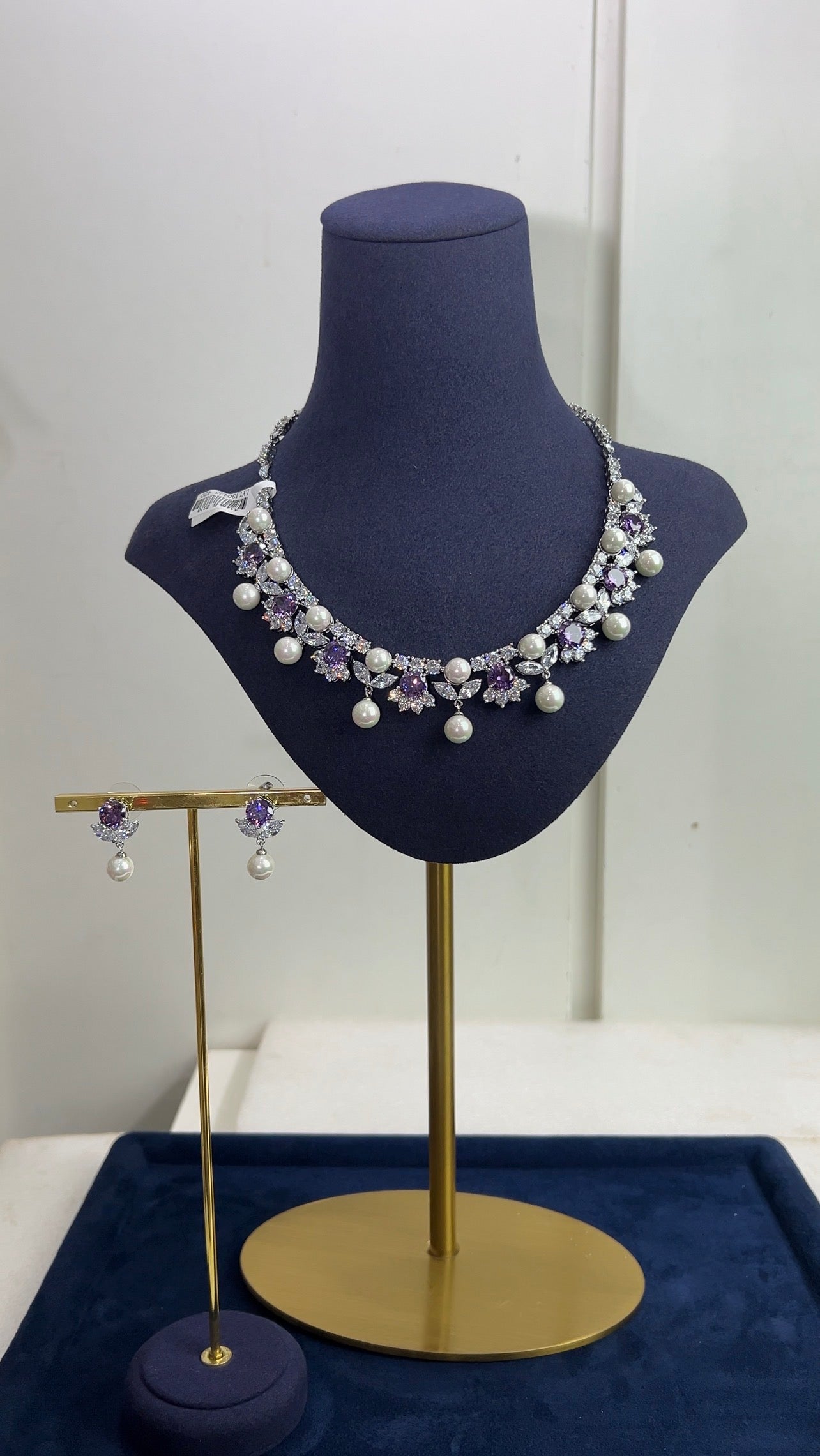Necklace and earrings on a mannequin bust with a white background