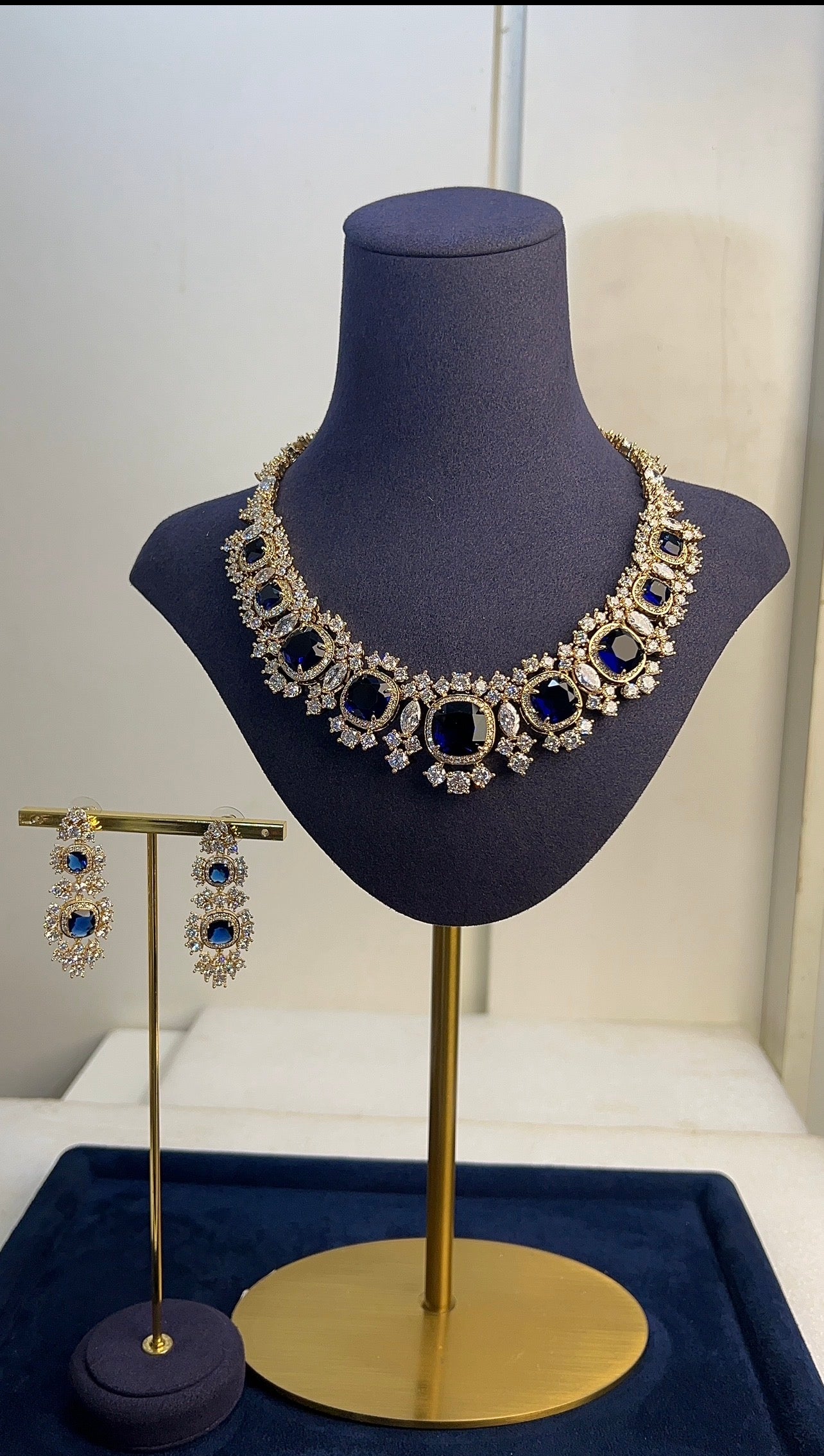 Necklace and earrings on a mannequin bust with a white background
