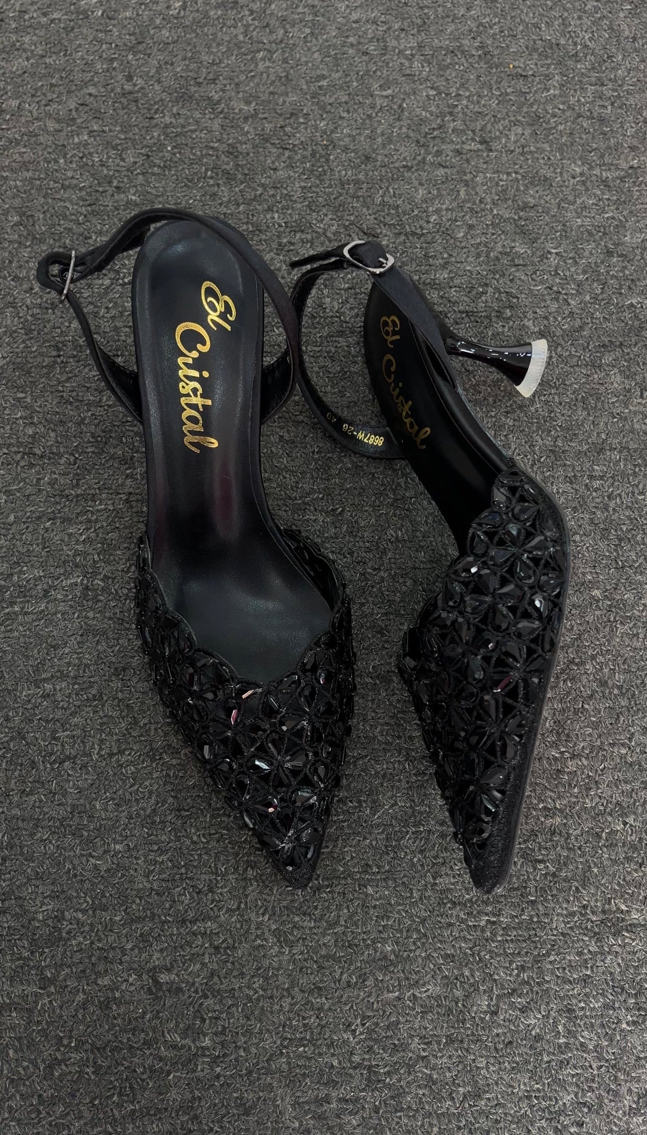A pair of pointed-toe slingback heels embellished with intricate floral crystal detailing, featuring a sleek silhouette and high heel, designed for an elegant and glamorous look.