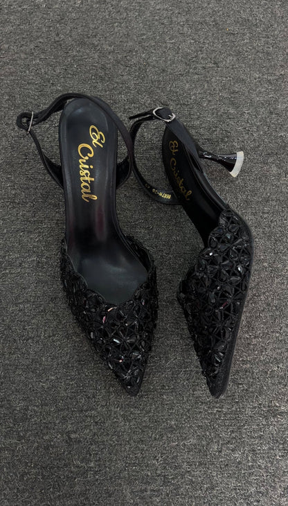 A pair of pointed-toe slingback heels embellished with intricate floral crystal detailing, featuring a sleek silhouette and high heel, designed for an elegant and glamorous look.