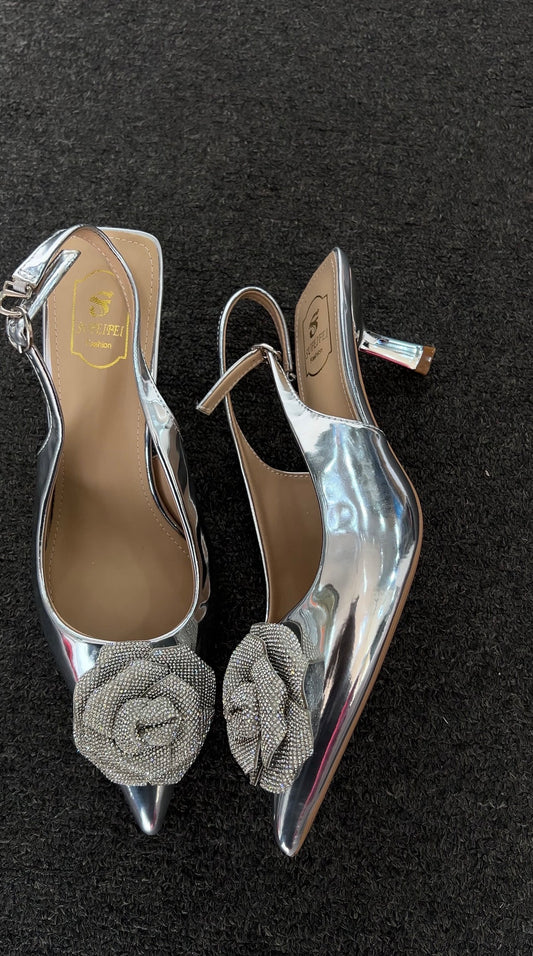 Pair of silver high-heeled shoes with floral embellishments 
