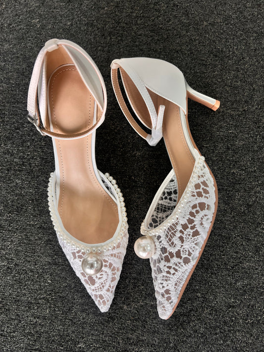 Pair of white lace-up high-heeled shoes with pearl embellishments