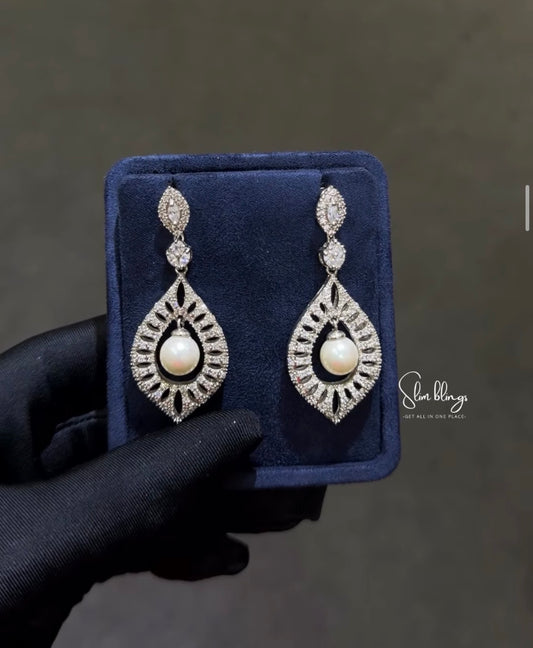 Featuring a crystal-paved Moroccan shield design with a suspended centerpiece pearl. Perfect for brides and formal wear.