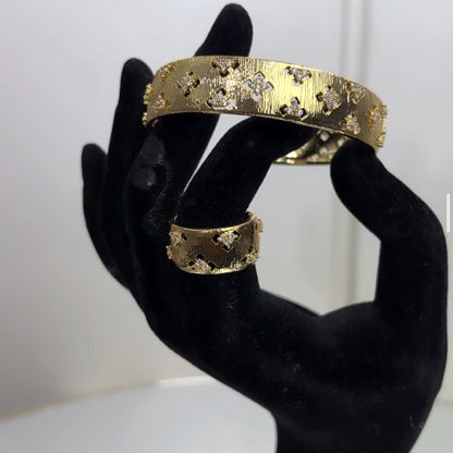 Crafted with a sleek hinged closure for effortless wear and a perfectly coordinated statement band ring, this duo offers unparalleled versatility.