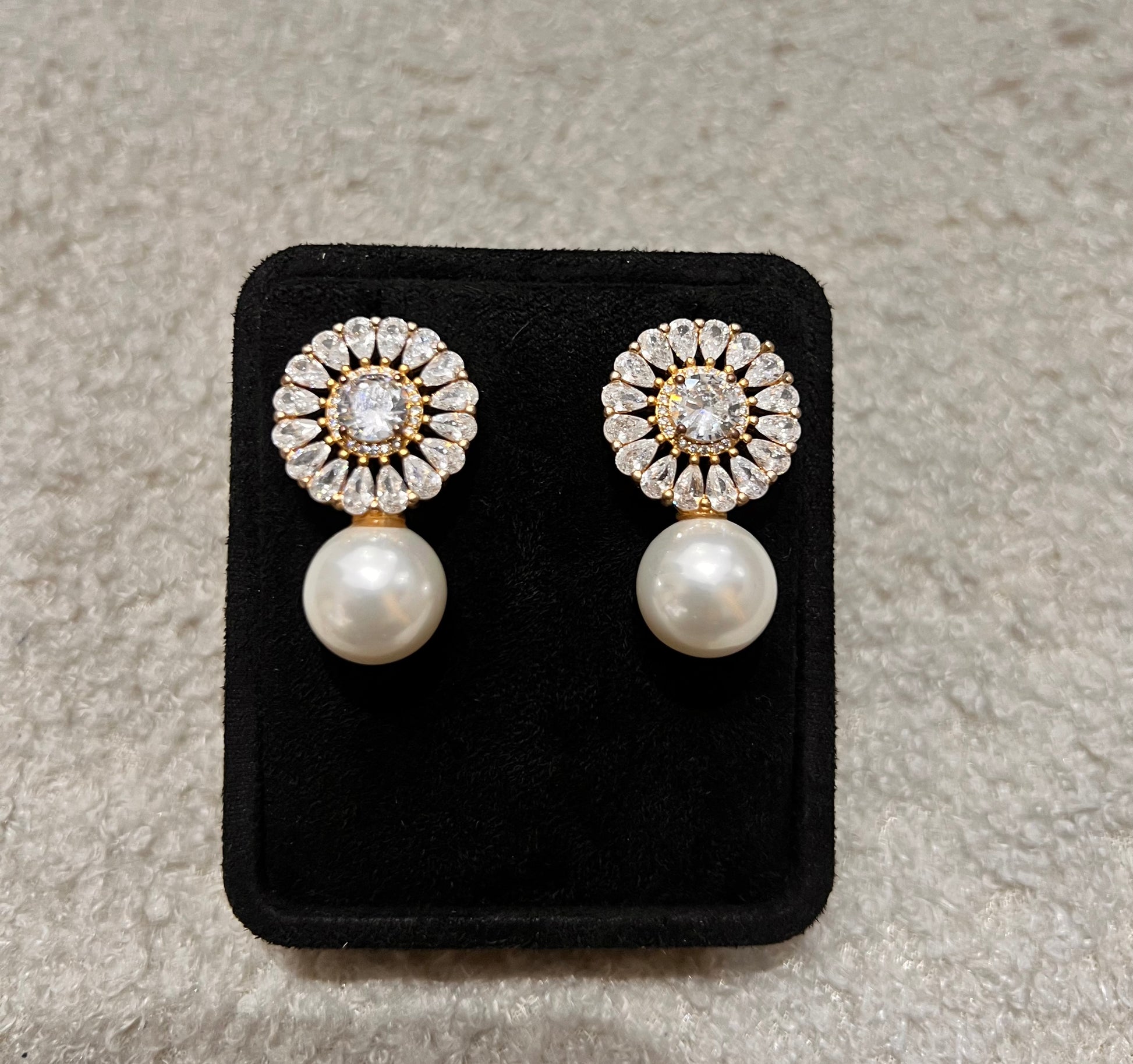 Pair of earrings with pearl and diamond-like stones. A perfect blend of classic romance and modern glamour.
