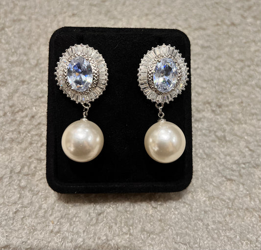 Pair of earrings with pearl drops and crystal-like tops.