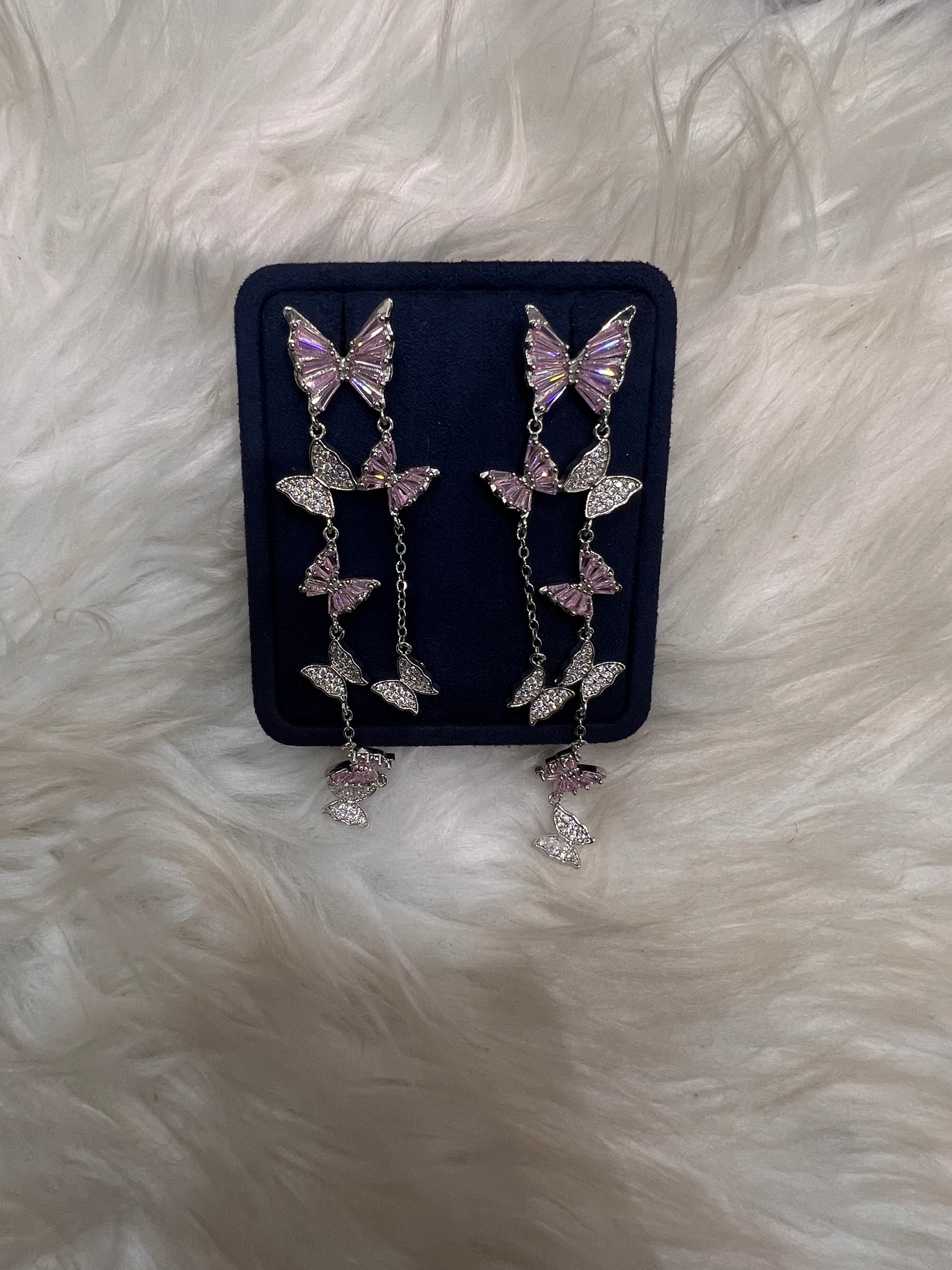 Butterfly-shaped earrings with pink gemstones. these pieces offer lightweight comfort, a smooth, snag-free finish, and maximum brilliance under the lights.