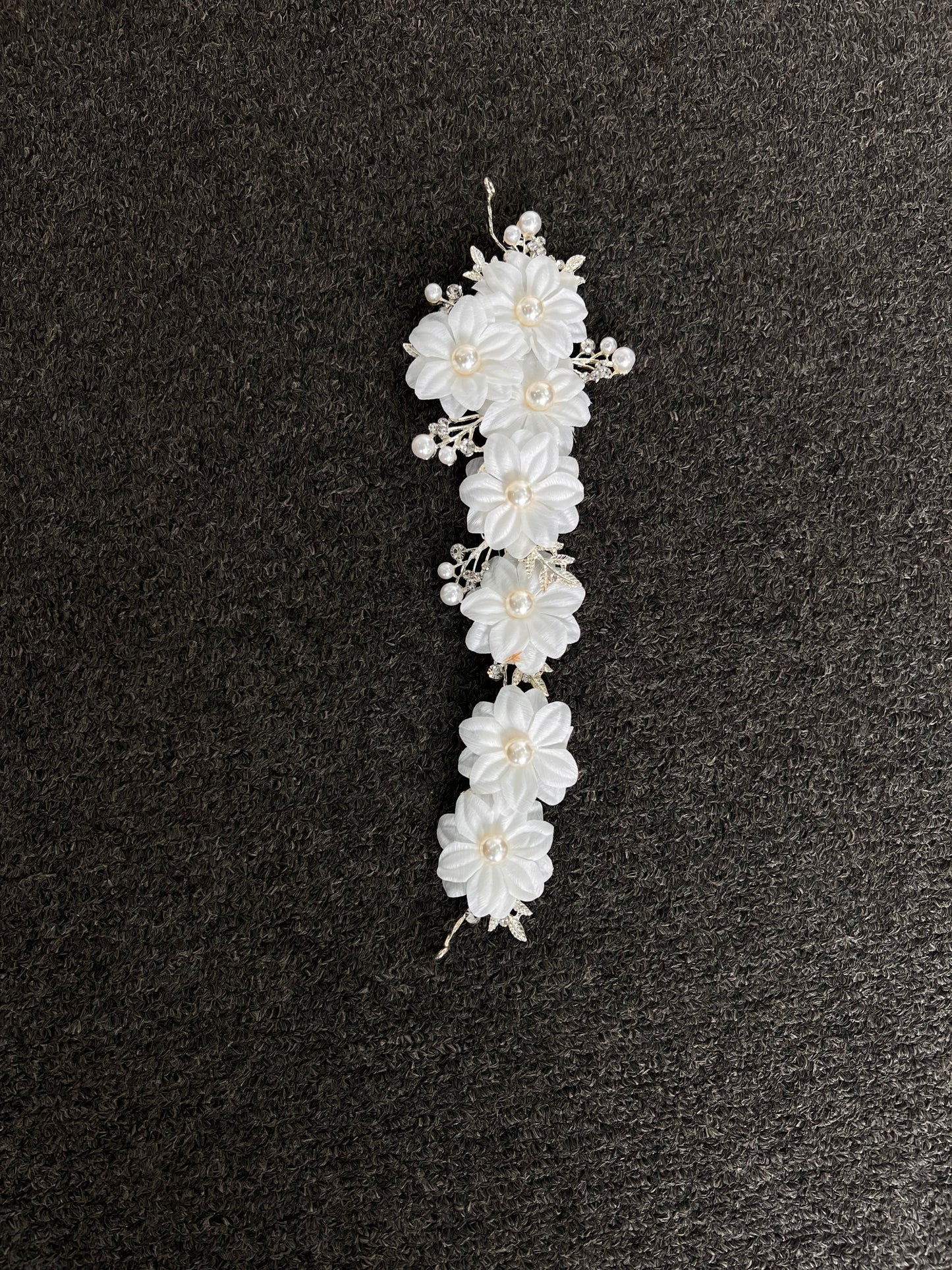 White floral hair accessory with pearls . Crafted with a premium, lightweight finish, it secures comfortably with bobby pins or ribbons for a luxurious, snag-free fit that lasts from the ceremony to the final dance.