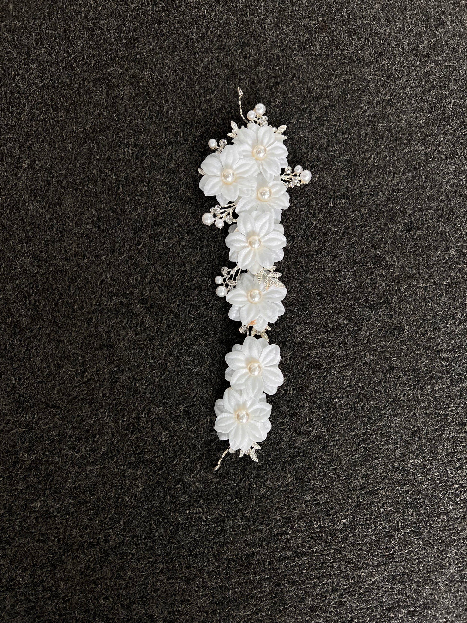 White floral hair accessory with pearls . Crafted with a premium, lightweight finish, it secures comfortably with bobby pins or ribbons for a luxurious, snag-free fit that lasts from the ceremony to the final dance.