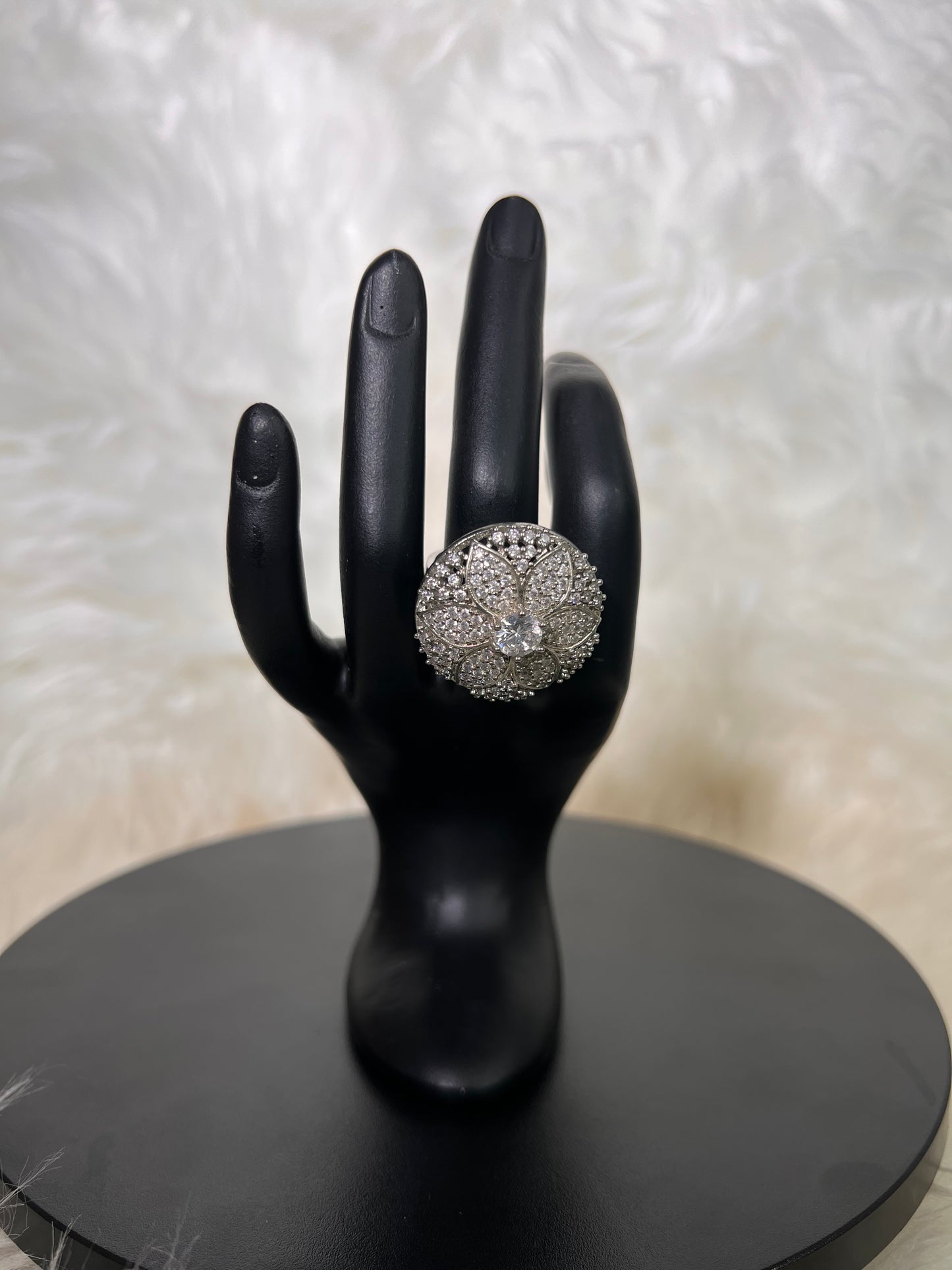 A spectacular, flat-set circular medallion featuring intricate filigree open-work petals and a majestic, clear center gemstone.