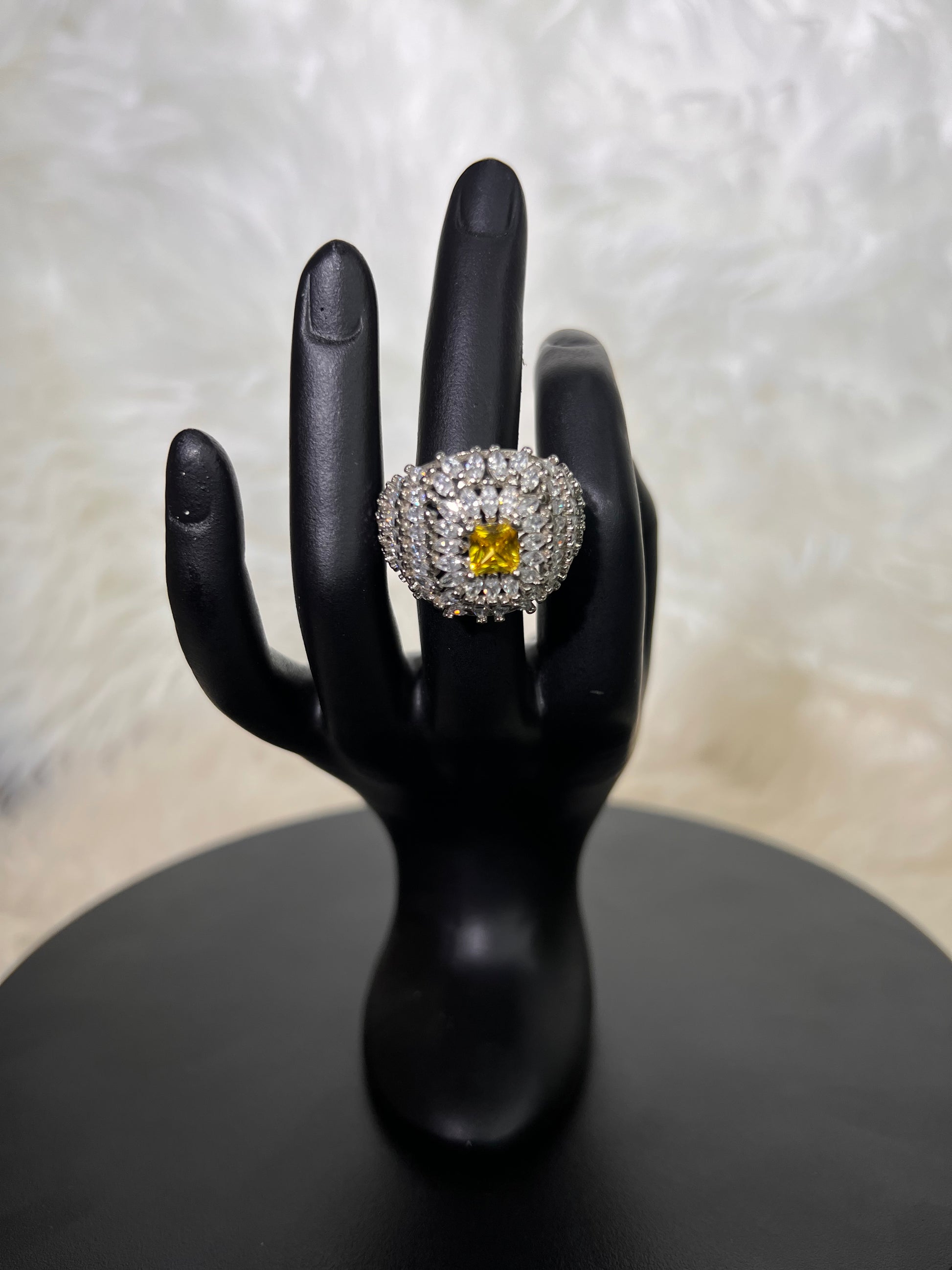 A striking radiant-cut canary yellow gemstone surrounded by an oversized, domed halo of multi-layered, brilliant-cut clear cubic zirconia. It delivers a sun-drenched sparkle with incredible three-dimensional depth.