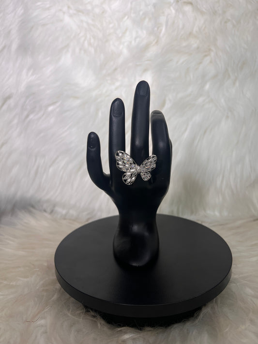 Features an open-wing silhouette accented by mixed round and marquise-cut crystal clusters.