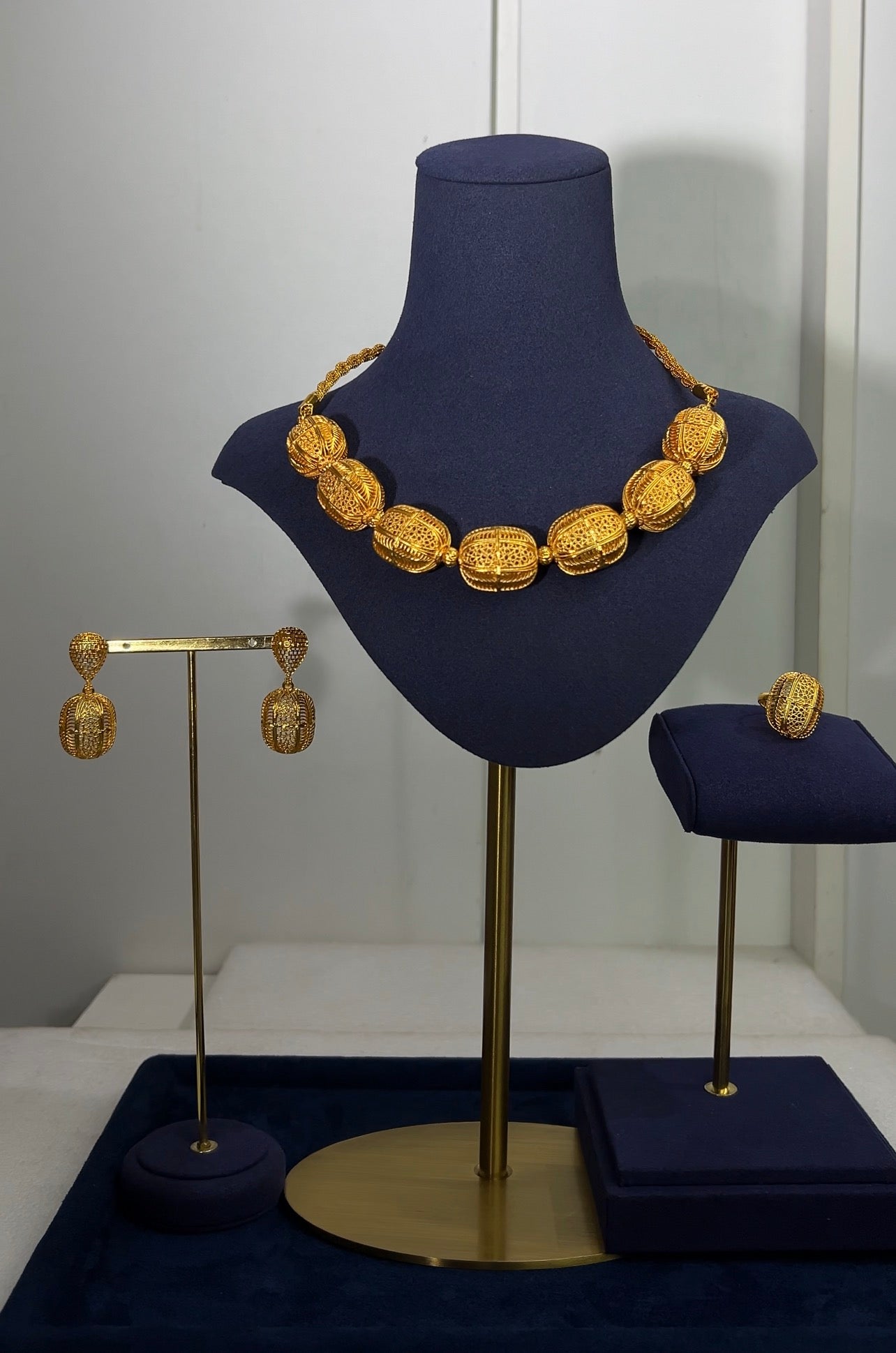 Finished with matching vertical barrel drop earrings and an identical statement cage ring, this suite brings a clean, rhythmic pattern to luxury accessorizing.