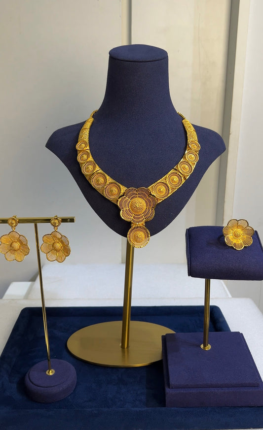 The set includes matching statement floral earrings and a prominent rosette cocktail ring, flawlessly combining mid-century classicism with rich, modern gold plating.