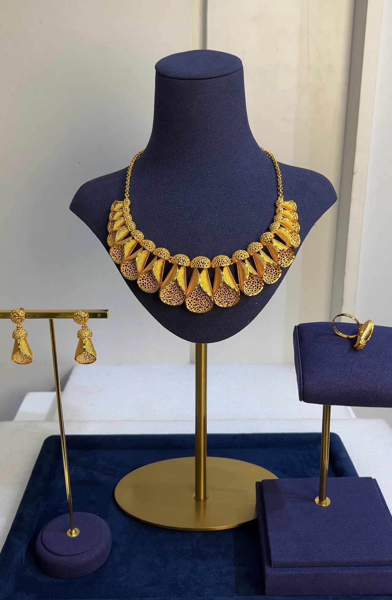 Paired with matching fluted drop earrings and a coordinated structural wrap ring, this set offers an avant-garde silhouette for sophisticated evening attire.
