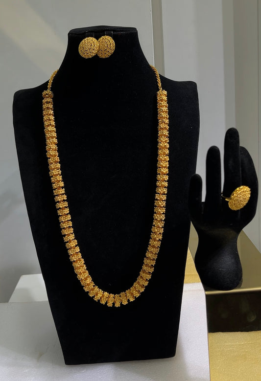 The minimalist yet textured set is paired down with sophisticated, matching round dome button earrings and a coordinating textured statement ring, allowing the sweeping necklace to take center stage.